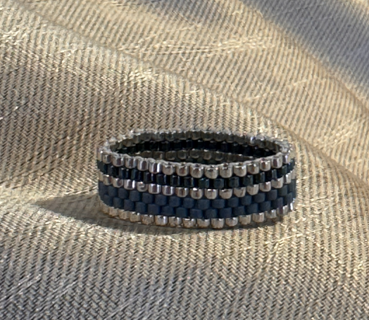 Schmaler, geflochtener Armband in Blau und Silber mit gestreiftem Muster.